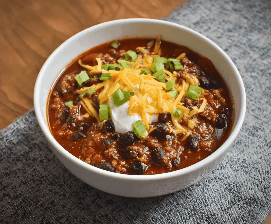 Hearty black bean chili topped with fresh cilantro and diced onions in a rustic bowl, perfect for a comforting meal.