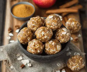 Healthy apple cinnamon pumpkin protein balls on a white plate, featuring a festive autumn flavor with fresh apples, cinnamon, pumpkin, and protein-rich ingredients.