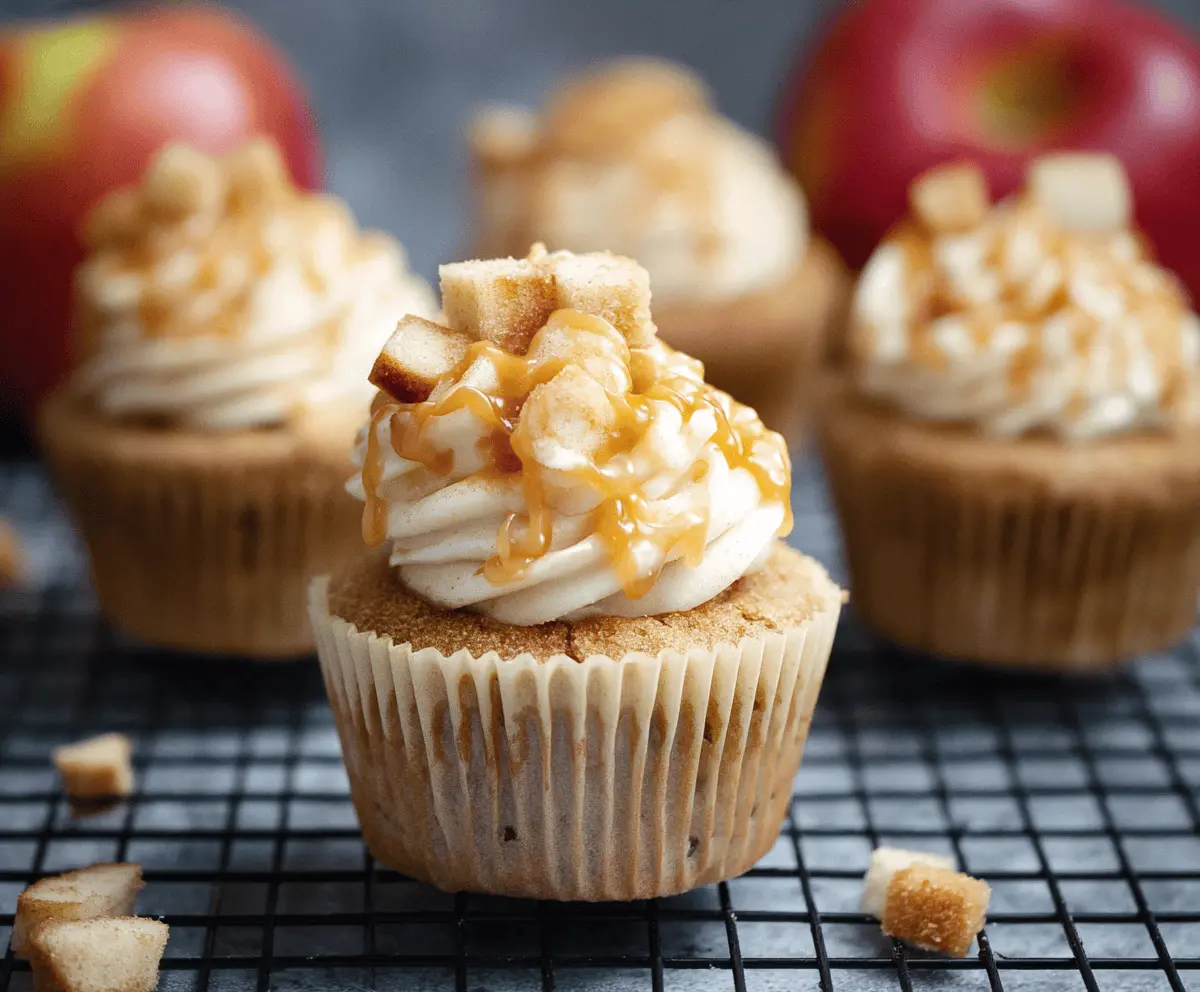 Delicious apple pie cupcakes topped with cinnamon and caramel glaze on a rustic wooden table.