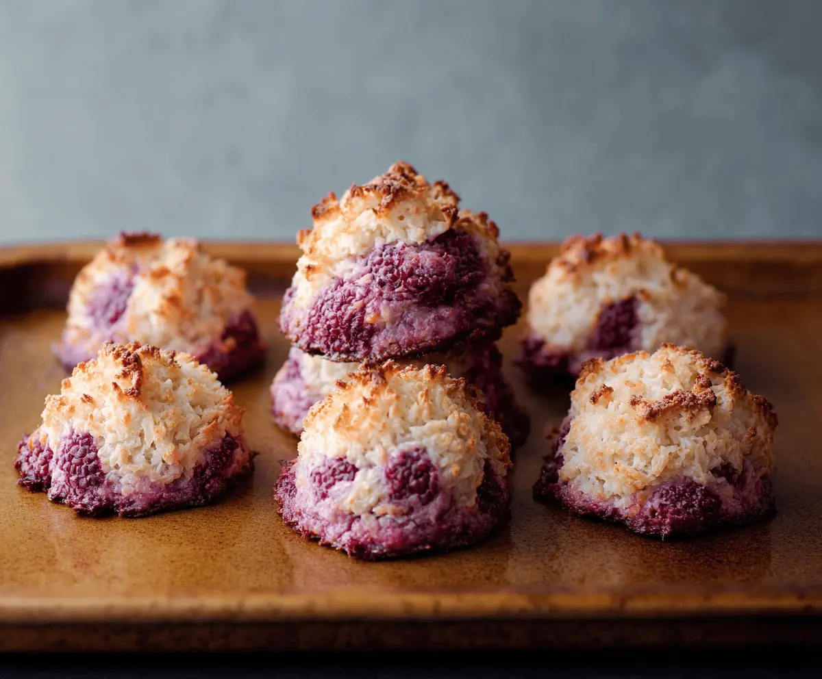 Delicious Raspberry Coconut Macaroons Cookies on a plate, showcasing golden-brown exterior with vibrant raspberry and coconut filling.