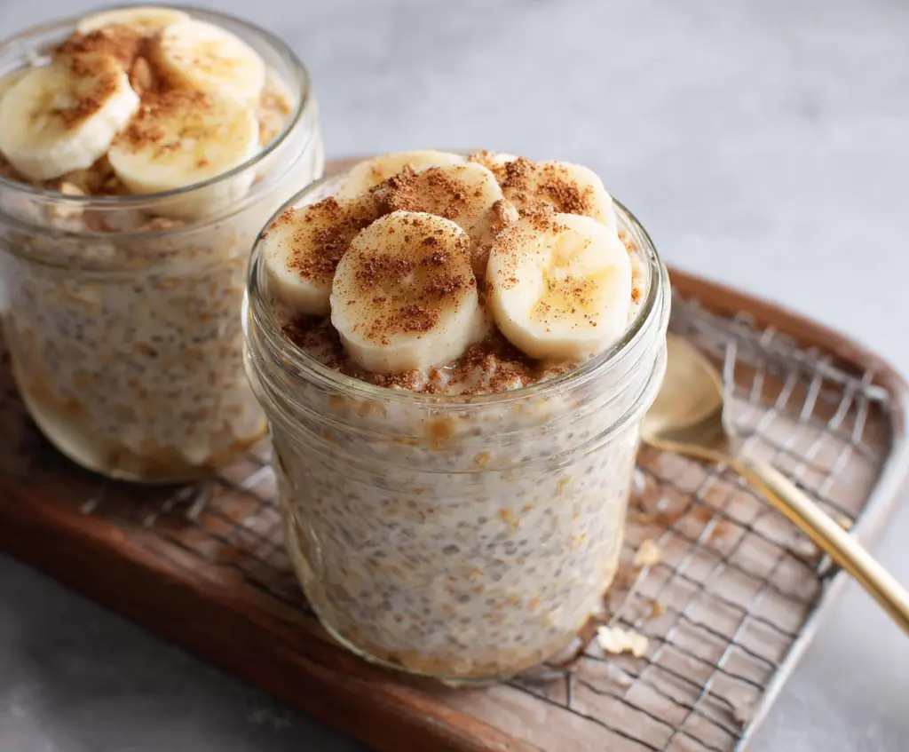 Healthy Banana Cinnamon Overnight Oats in a glass jar featuring sliced bananas and a sprinkle of cinnamon.