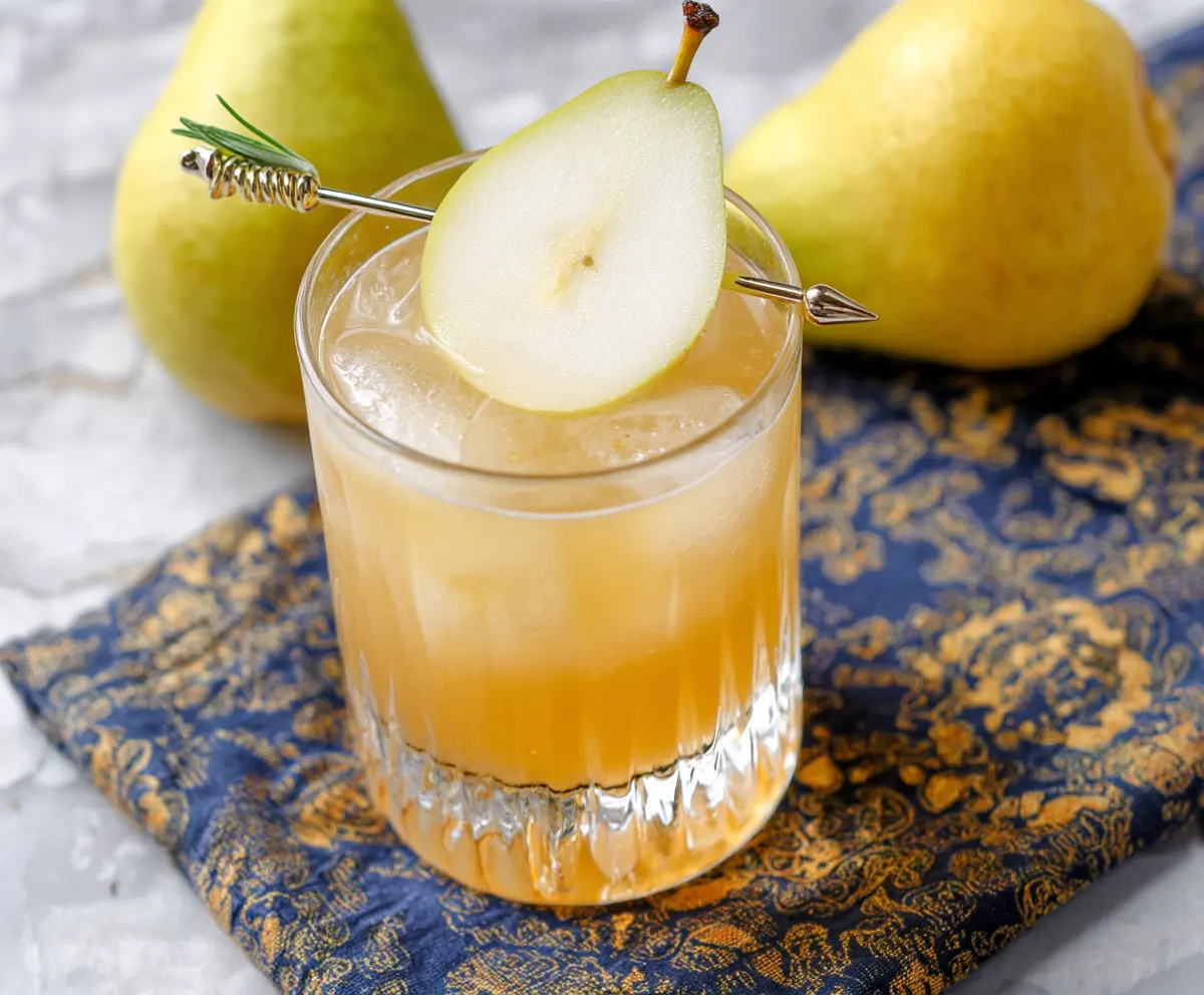 Refreshing Ginger Pear Bourbon Cocktail in a glass with fresh pear slices and ginger garnish