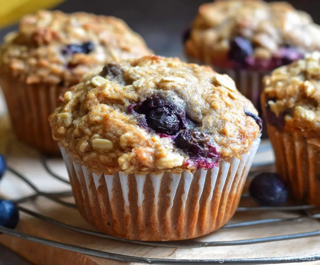 Fresh banana and blueberry oatmeal muffins on a baking tray, perfect for breakfast or a healthy snack.