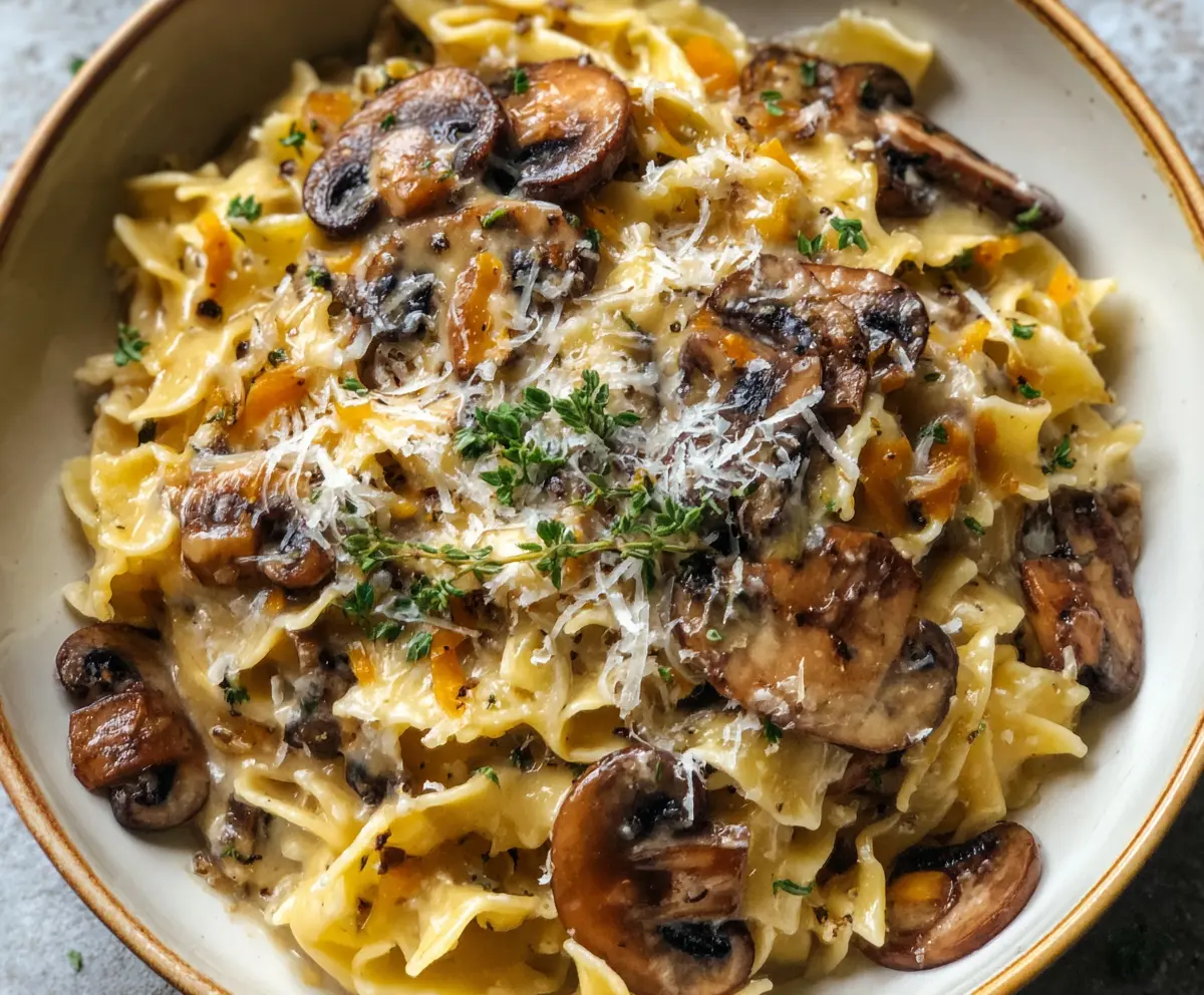Delicious caramelized leek and mushroom pasta topped with melted Gruyère cheese