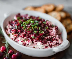 Creamy cranberry and jalapeno cream cheese dip served with fresh herbs.