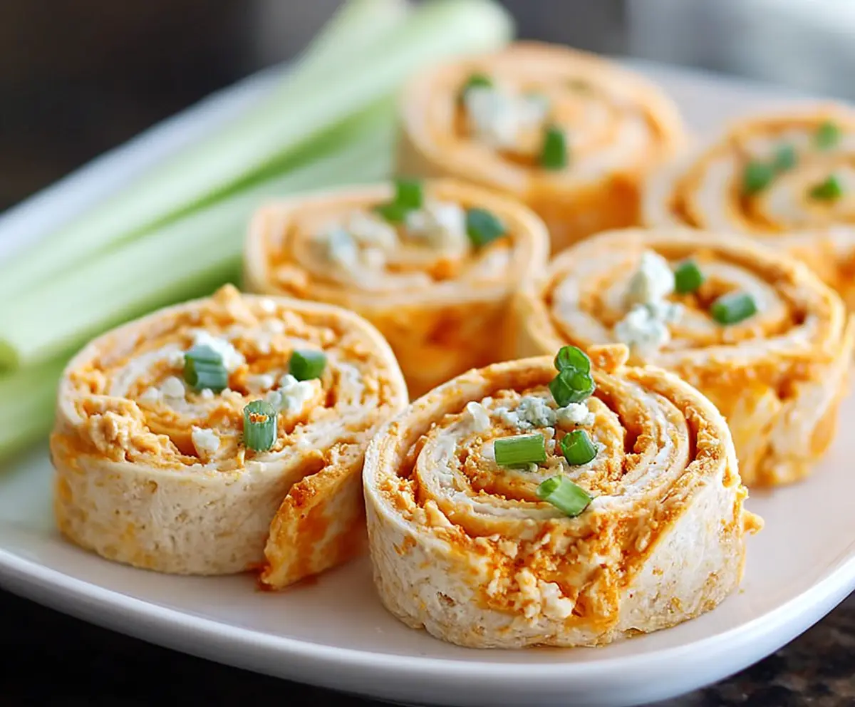 Creamy buffalo chicken pinwheels with melted cheese and crispy tortilla rolls, perfect as a savory appetizer.