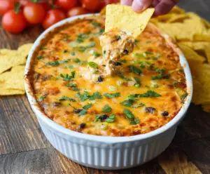 Delicious chicken enchilada dip with melted cheese and savory ingredients, perfect for parties.