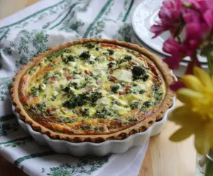 Delicious Easter brunch quiche with a golden crust and colorful vegetable toppings on a rustic plate.